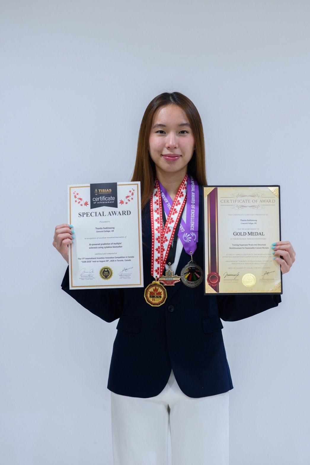 Winnie holding her iCAN 2026 Gold Medal certificate and medals