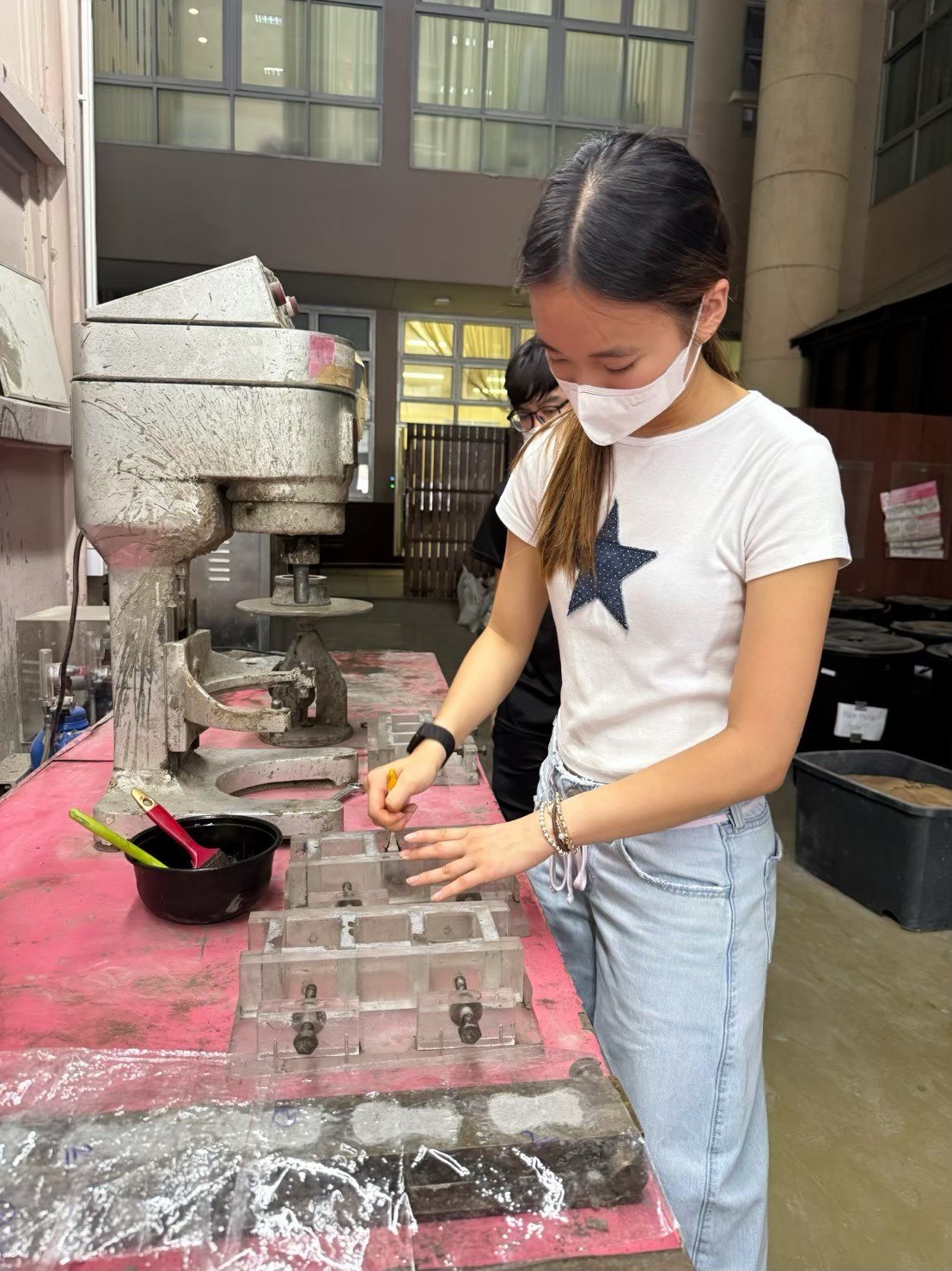 Winnie preparing cement mortar moulds