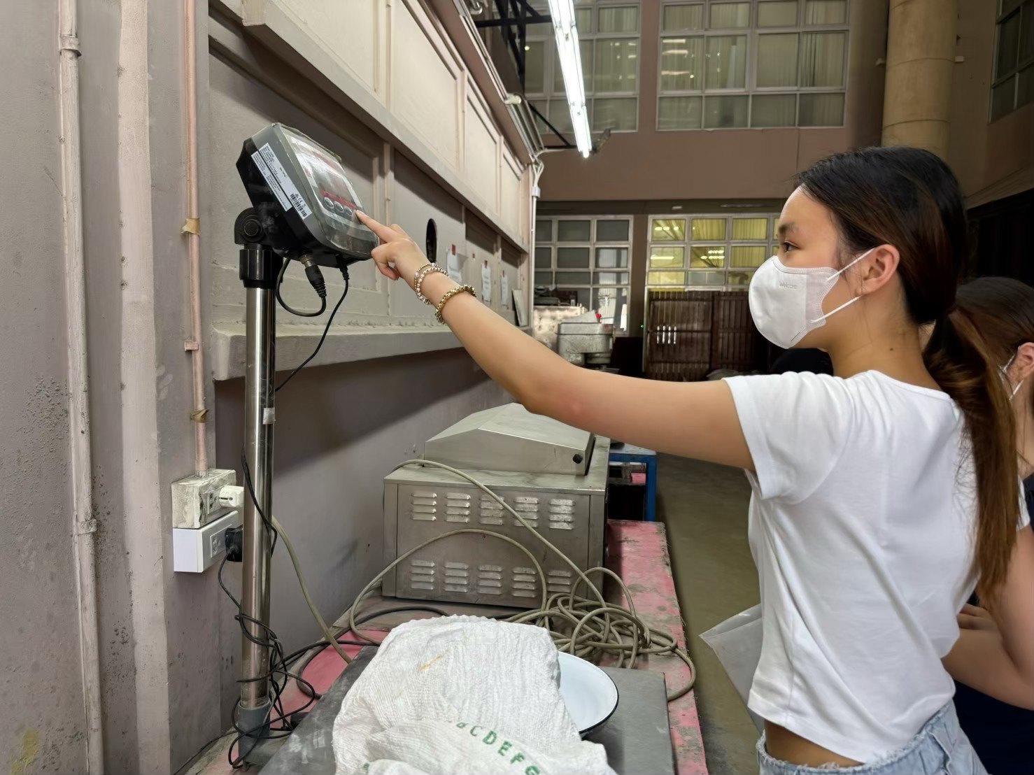 Winnie reading a digital scale while weighing samples